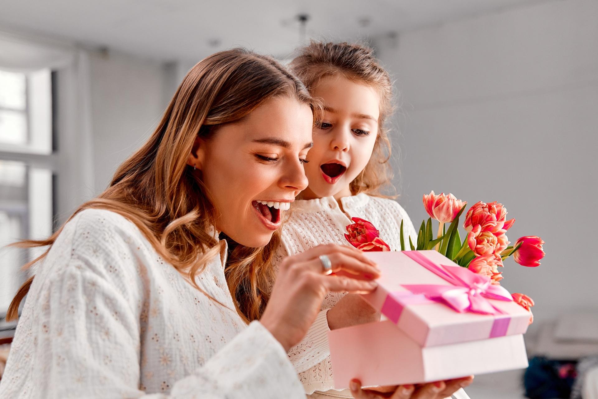 Mutter öffnet Geschenk mit Blumen | Geschenke zur Geburt

