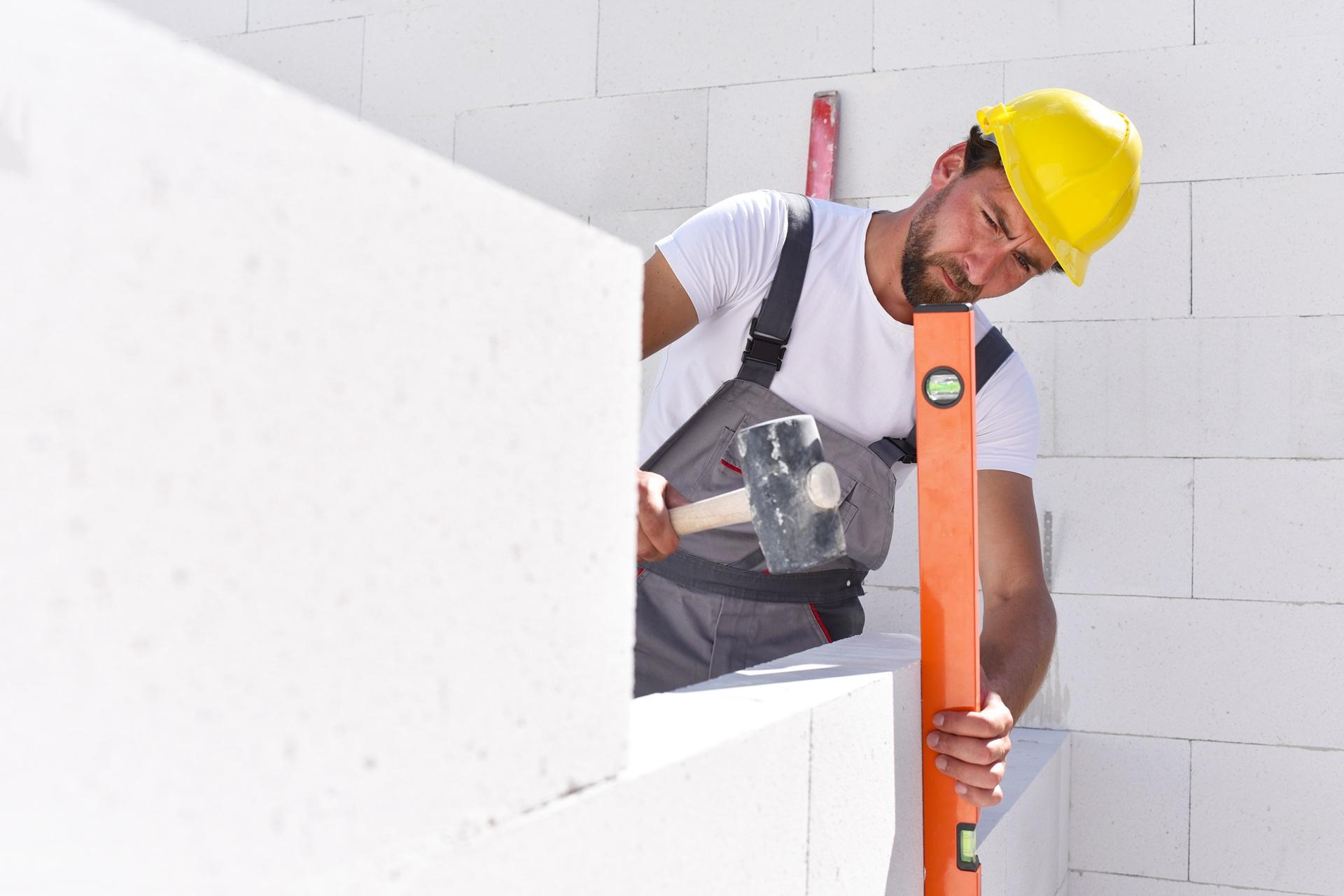 Maurer richtet Wand mit Wasserwaage aus | professionelle Terrassenüberdachung Köln